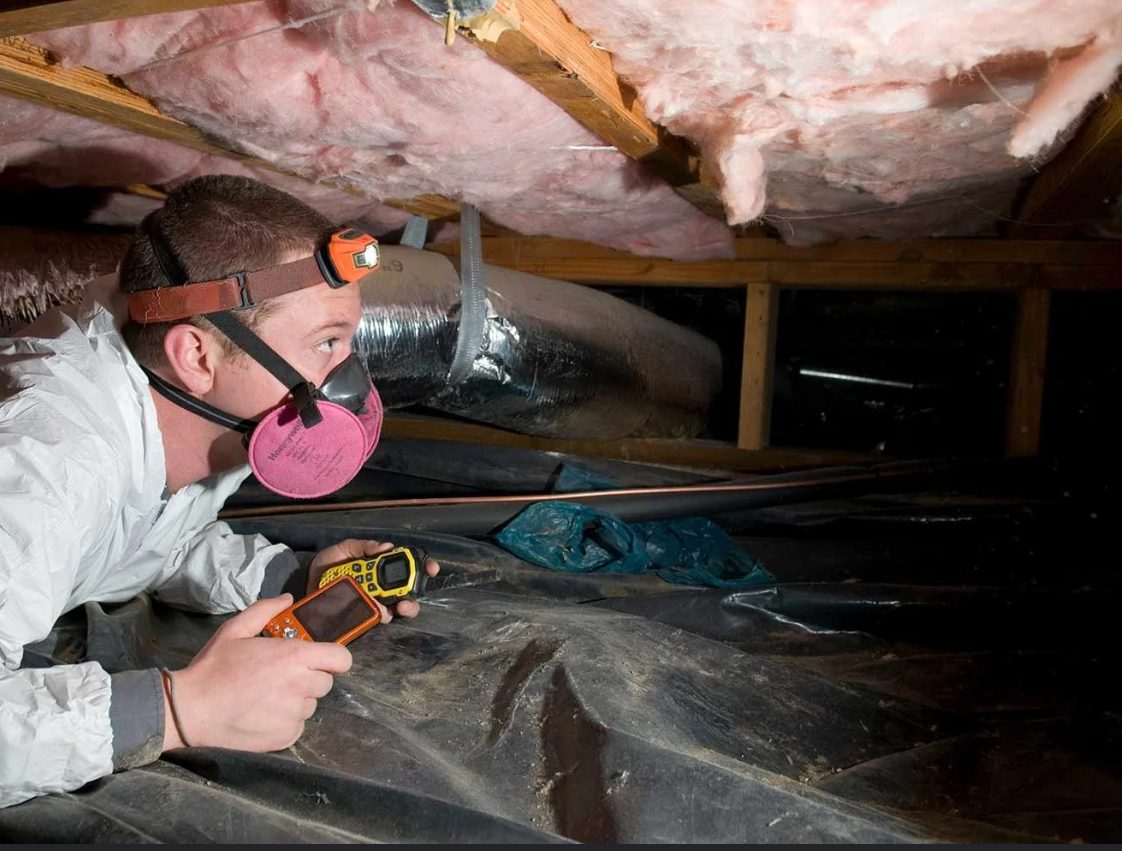 Insulation specialist inspecting attic insulation and ductwork